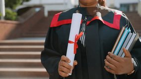 African american female graduate holding diploma and books in hand - Powered by Shutterstock - Get 15% off with code: PIKWIZARD15