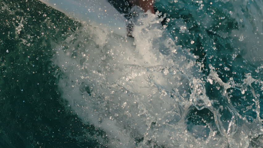 Slow motion water splashing as wake surf board lands trick