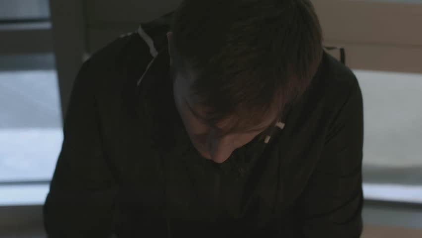 Man is calling excitedly on phone. Stock. Close-up of man calling and talking on phone. Man is making phone call on background of windows