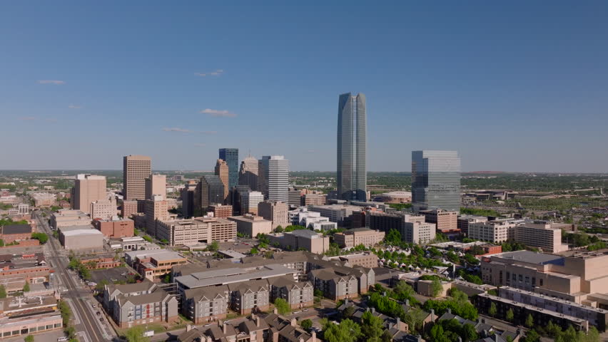 Oklahoma City's modern skyline from an aerial point of view, featuring tall buildings and a bustling downtown area on a sunny day
