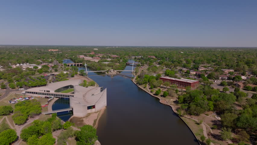 Aerial view Arkansas River in Wichita, modern buildings, and greenery, capturing the stunning urban landscape from above