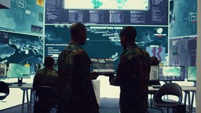 Intelligence analysts supervising and coordinating the big data analysis, processing tactical information to help the field troops. Officers monitoring real time warfare information. Camera B. - Powered by Shutterstock - Get 15% off with code: PIKWIZARD15