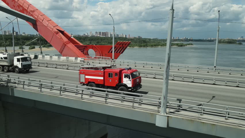 Fast red fire truck drive highway. Drone view from above. Emergency firefighter transport hurry rescue lives. Rush driver move city street road. Bad accident call 911. Siren light. Flame incident.