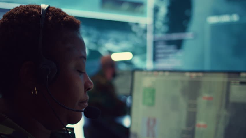 Woman military personnel tracking enemy vessels on the coast line territory, working on national safety and providing real time data to the dispatch center. Reconnaissance system. Camera B.