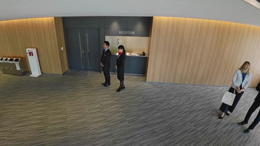 Aerial view of people at the hotel reception desk from a security camera
