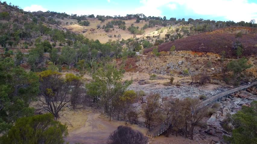 Dolly right clip of Bells Rapids Bridge with walkers crossing dry Swan River