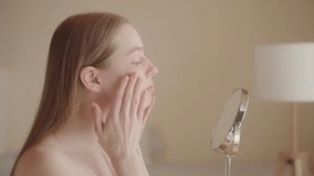 Blonde gorgeous woman applies moisturizer or sunscreen, morning beauty routine. Young Caucasian woman applying makeup foundation. Makeup preparation. Skin care. Daily beauty routine. - Powered by Shutterstock - Get 15% off with code: PIKWIZARD15