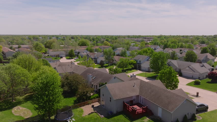 Aerial view of a peaceful american suburb with tidy homes, lush lawns, and treelined streets, showcasing tranquil community living in the usa