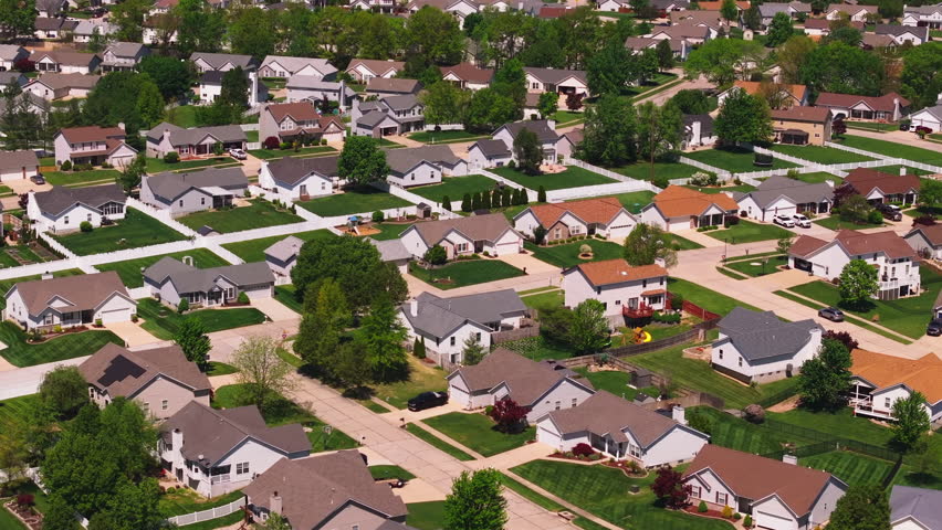 Tranquil american suburb from a bird's eye view. Neat houses, lush lawns, and calm streets form a peaceful residential area