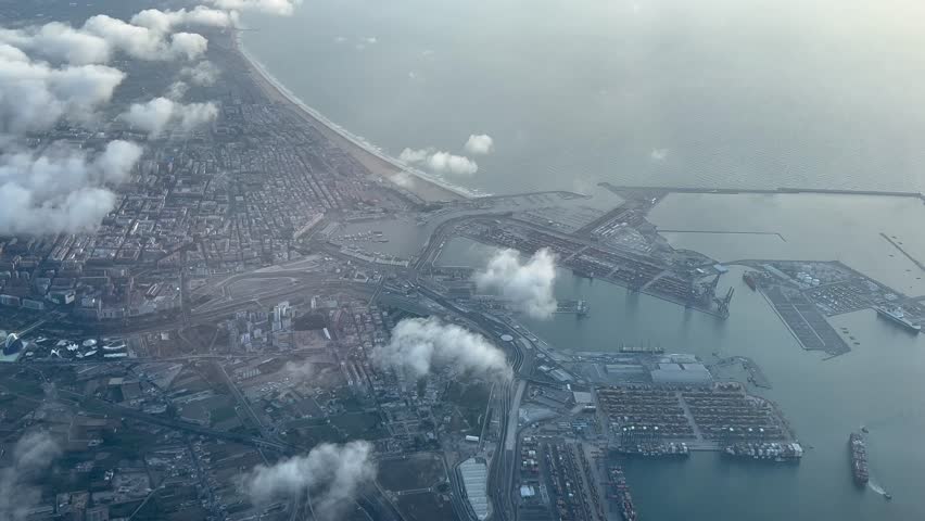 Spinning aerial view of Valencia city, Spain. Shot from an airplane cockpit at 3000m high. Early morning light with some low clouds. 4K 60FPS