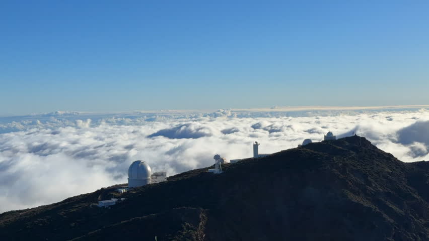 Timelapse of the Roque de Los Muchachos observatory on the island of La Palma, with large moving clouds on a sunny day.