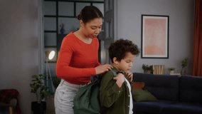 African American family at home childcare mother mum woman female in living room help little boy child schoolboy kid put on schoolbag backpack preparing son going back to school education studying - Powered by Shutterstock - Get 15% off with code: PIKWIZARD15