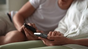 Relaxed young couple tapping together smartphone screen to farming new popular Hamster Kombat cryptocurrency in mobile phone online application, sitting on sofa at home. Shooting in slow motion. - Powered by Shutterstock - Get 15% off with code: PIKWIZARD15