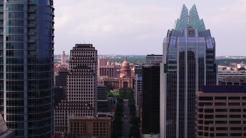 Aerial view of the cityscape of Austin with its modern skyscrapers and the iconic Texas capitol building in the distance
