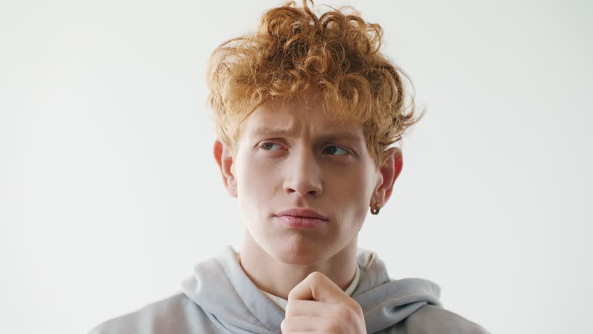 Young Caucasian guy standing close to camera. Handsome man thinking about something. Making important decision and raising finger. Having good ideas or plans. Pondering deeply.