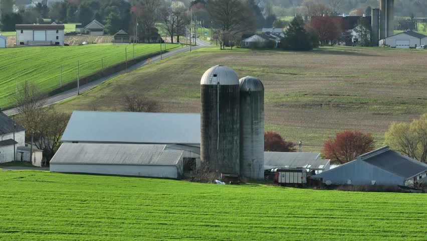 Rural American farm during spring. Aerial rising shot with zoom lens revealing USA countryside.