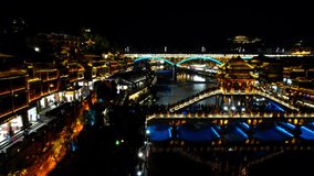 Illuminated Snow Bridge and Nanhua Bridge over Tuo Jiang in Fenghuang Old Town, China. Aerial parallax - Powered by Shutterstock - Get 15% off with code: PIKWIZARD15