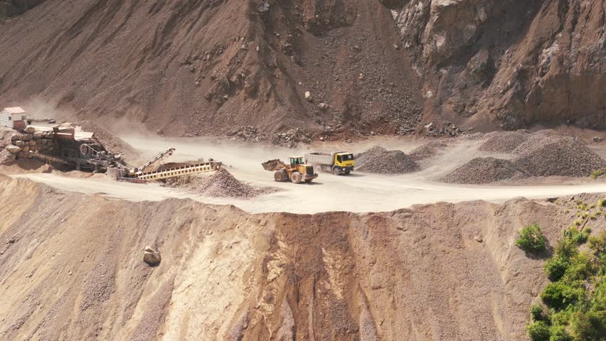 Detail view of a mining bulldozer dumping tailings into a cliff at a limestone mine in northern Argentina, Jujuy Province, lithium tringulum.