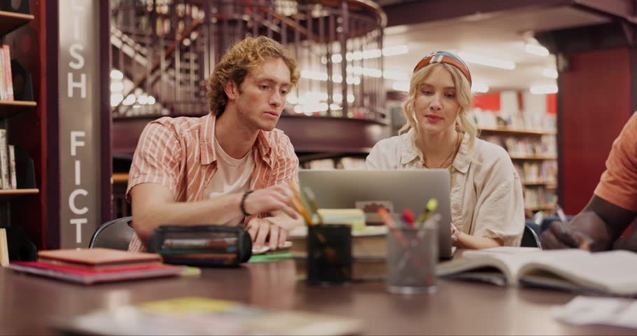 Laptop, learning and friends studying at library for education, knowledge or test preparation in college. University students, man and woman on computer for help, writing notes and team collaboration