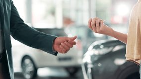 Handshake, deal and car dealership with salesman and customer in showroom for purchase discussion. Transport, vehicle keys and automobile dealer agreement to buyer after sale pitch for auto travel - Powered by Shutterstock - Get 15% off with code: PIKWIZARD15