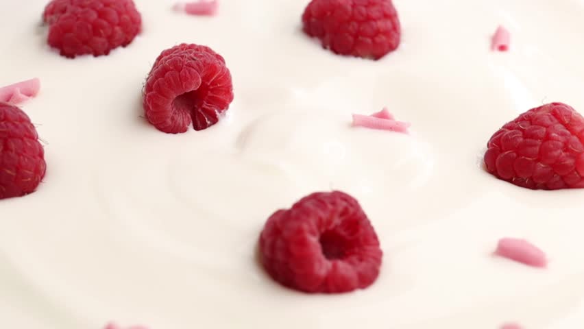 Natural yogurt with raspberry, rotation in circle. background for raspberry-flavored dairy products and pink chocolate