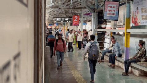 Kalyan , Maharashtra , India - 06 05 2024: Passengers at railway station bustle around a halted train, seen from its door Redaksjonell arkivvideo