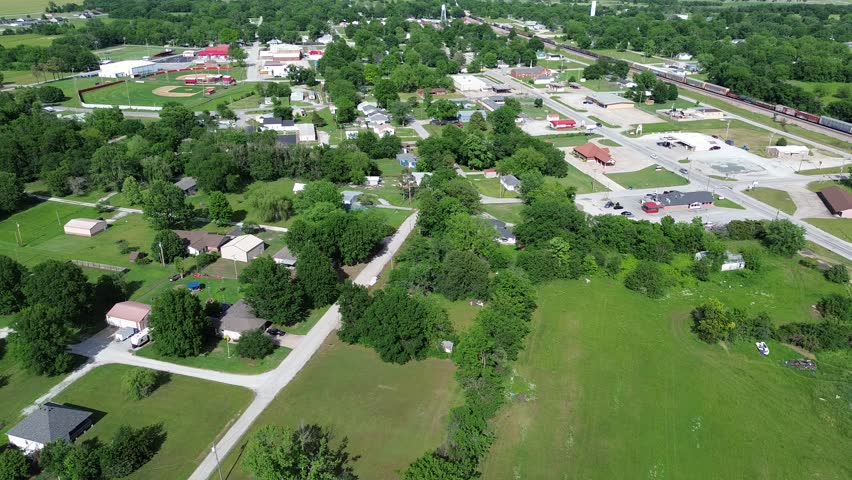Flyover Fairland agriculture town along Conner Avenue with baseball fields, railroad tracks, low density business and residences building, southern Ottawa County, Oklahoma, agro-town country area. USA