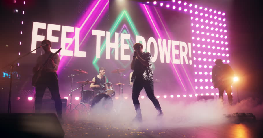 Energetic Rock Band Performing on a Nightclub Stage with Dynamic Lights, Animated LED Screen and Special Effects. Rock Music Artists Creating a Unique Show Experience With Powerful Alternative Music
