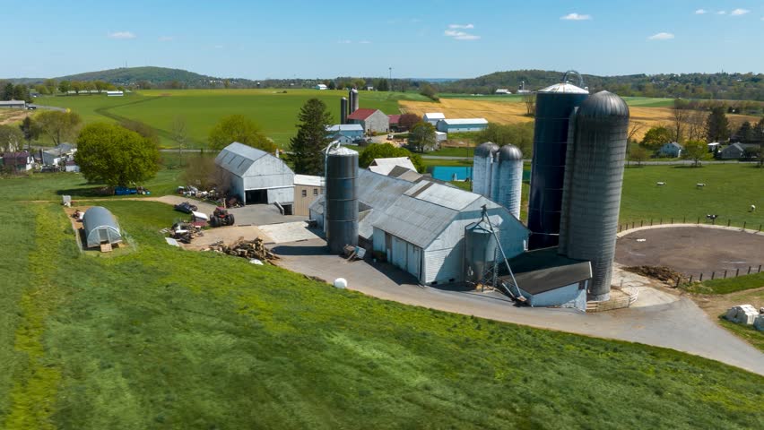 Rural farms in USA. Aerial hyperlapse revealing barns, silos, and houses in American countryside during spring.