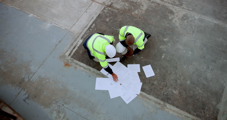 Construction, people and architect with documents in discussion for planning, teamwork and feedback. Top view, communication and contractor with paper for civil engineering, project and blueprint