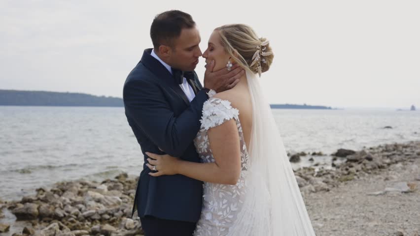 Bride and groom pose on beach