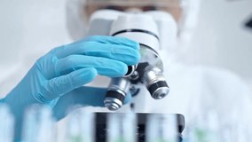 Professional scientist in protective gear is using microscope in a laboratory setting, close-up. Science and medicine concepts - Powered by Shutterstock - Get 15% off with code: PIKWIZARD15