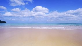 Summer sea background.Blue sky white clouds over ocean waves break on sand beach.Waves crashing against an empty beach.Sea waves and beautiful sand beach in Phuket Thailand. High quality video