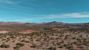 Aerial Flight in the american desert. Hot sunny day. Drone cinematic shot of a desert mountain landscape, dry semi-arid american region. Sand mountains and shrubs. Sedona Arizona desert - Powered by Shutterstock - Get 15% off with code: PIKWIZARD15
