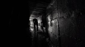 A man with a lantern walks in an underground concrete rain collector. - Powered by Shutterstock - Get 15% off with code: PIKWIZARD15