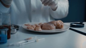 Hands male laboratory technician injects syringe into meat fillet chicken for GMO research. Genetically modified meat. Scientist injecting GMO into meat. Experiment with organic nutrition supplements - Powered by Shutterstock - Get 15% off with code: PIKWIZARD15