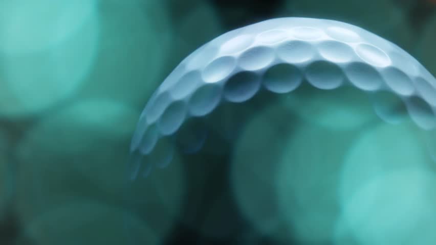 Planet Golf Ball Spinning golf ball moving from left to right in frame. Slow motion,Studio shot,back lit, Defocused Light. - Powered by Shutterstock - Get 15% off with code: PIKWIZARD15