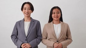 Asian businesswomen bowing in white background - Powered by Shutterstock - Get 15% off with code: PIKWIZARD15
