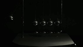 Newton cradle balancing balls in a dark tone. movement physics and common physical laws concept for action and reaction, cause and effect. Balls Newton. - Powered by Shutterstock - Get 15% off with code: PIKWIZARD15