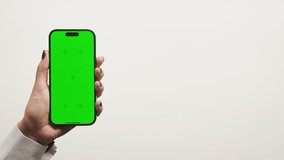 Hand holding smartphone with green screen on white background - Powered by Shutterstock - Get 15% off with code: PIKWIZARD15