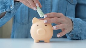 Woman putting paper money into piggy bank for saving. Money accumulation, pension, home buying. Savings and finance accounting concept - Powered by Shutterstock - Get 15% off with code: PIKWIZARD15