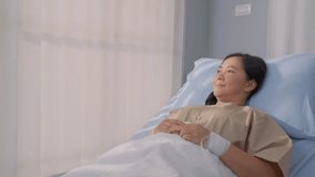 Asian mature female patient getting saline solution in hospital ward. Senior elderly sick woman lying down on bed in the recovery room, waiting for treatment from medical doctor in health care clinic. - Powered by Shutterstock - Get 15% off with code: PIKWIZARD15