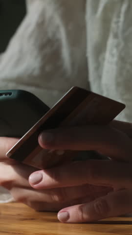 Vertical video. Paying online. Woman making payments on e-commerce sites with bank card. 