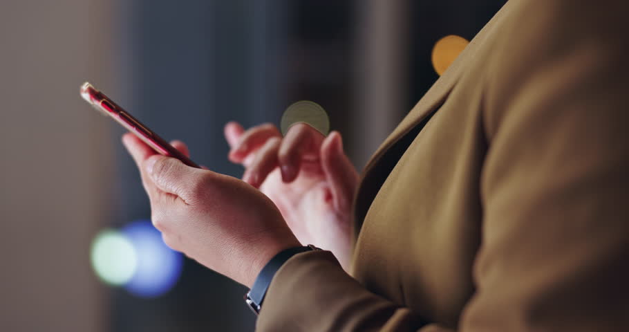 Business person, hands and night with phone for comunication, social media or research at office. Closeup of employee typing on mobile smartphone for online browsing, scrolling or app at workplace