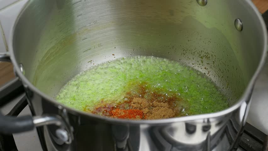 Cooking Video. Close up of food cooking simmering in a pan full of curry sauce, soup or stew placing ingredients herbs spices pan ready for cooking. Happy household chores healthy eating concept.