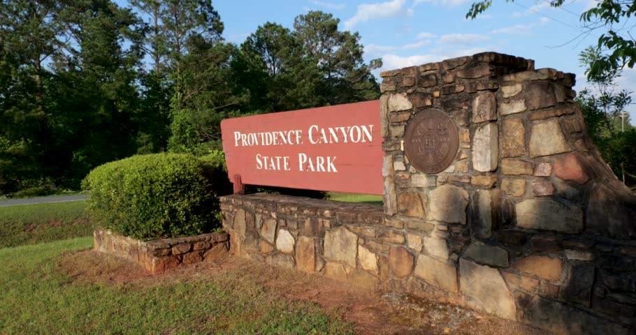 Close up slanted view of Providence Canyon State Park sign in Lumpkin Georgia on bright sunny day
