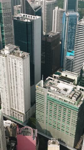 Flying over the condominiums and high rise buildings in Makati City. Metro Manila, Philippines. Cityscape. Vertical view.