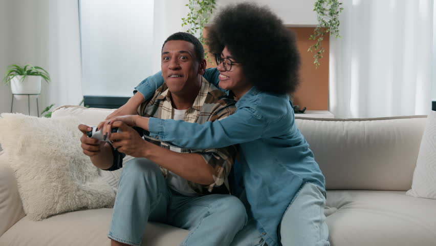 African American internet game addict man guy boyfriend male fight competition fighting with woman female girl girlfriend take away one joystick push playing console gaming online at home couch couple - Powered by Shutterstock - Get 15% off with code: PIKWIZARD15
