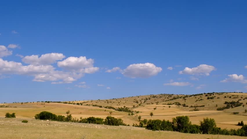 Clouds moving over yellow hills 