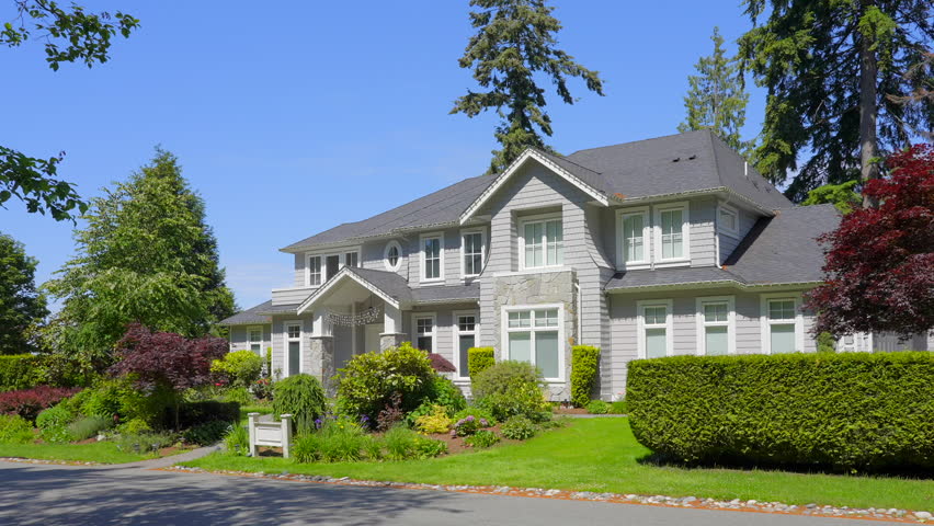 Establishing shot of luxury house with big tree and nice spring blossom landscape in Vancouver, Canada, North America. Day time on June 2024. ProRes 422 HQ.